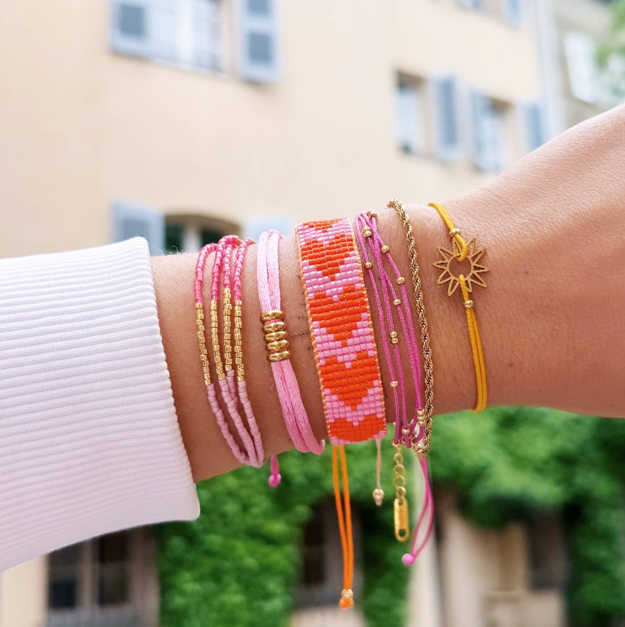 Bazou - Gevlochten armband met kraaltjes hartjes roze/oranje
